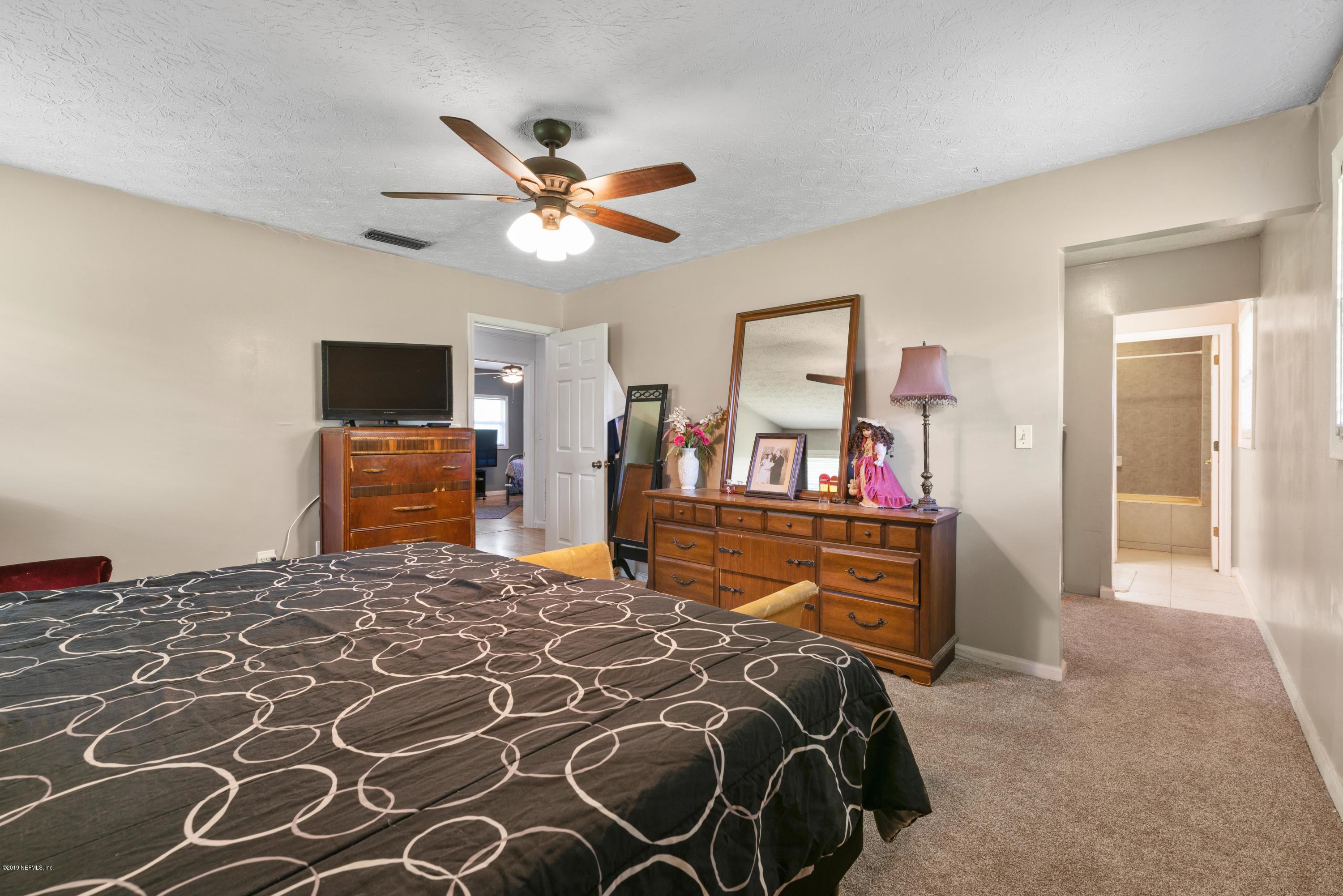 54152 Snyder Road Callahan, FL 32011 - Photo 24 of 39 a bedroom with a bed and a chandelier