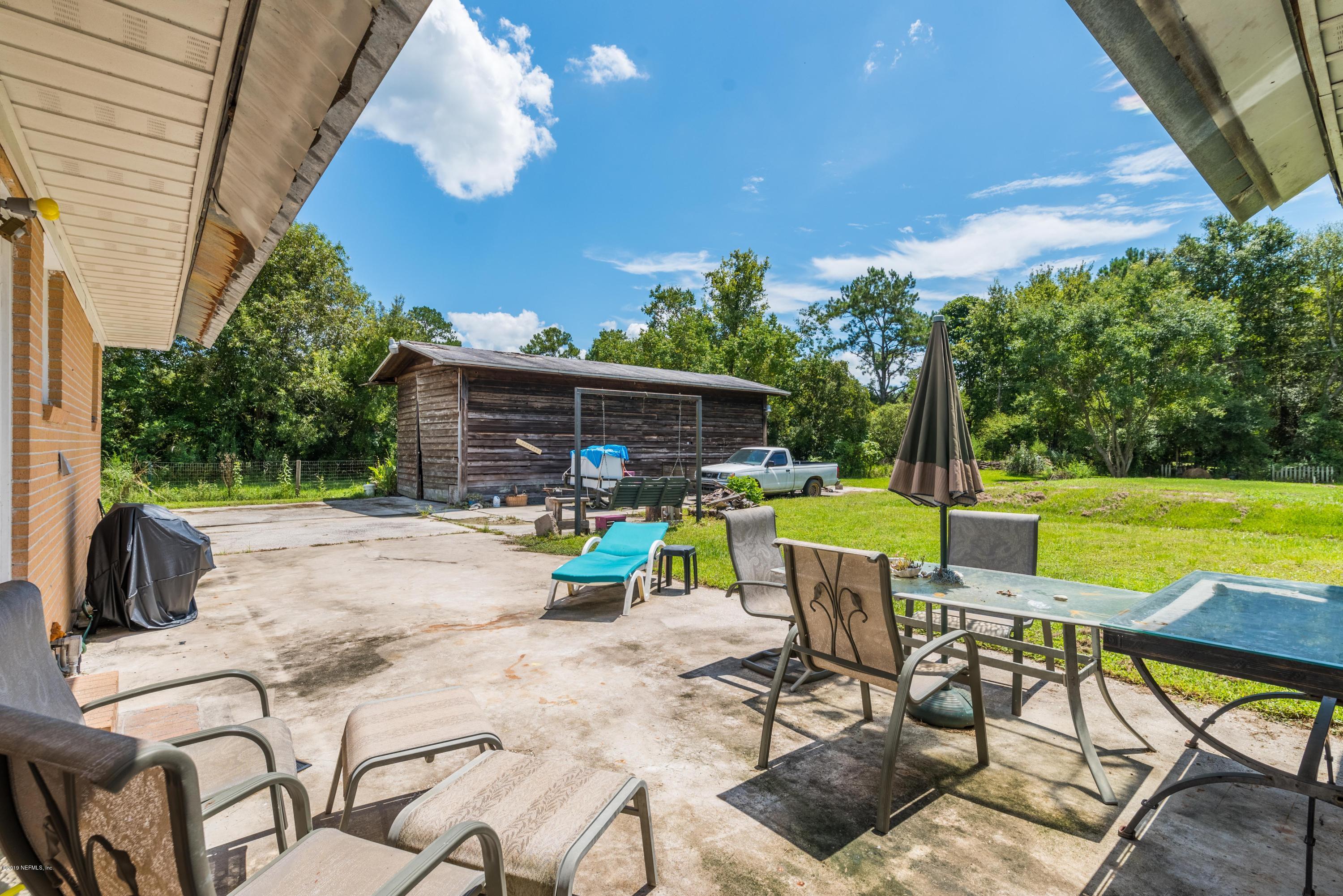 54152 Snyder Road Callahan, FL 32011 - Photo 31 of 39 a view of a patio with a table chairs and a backyard