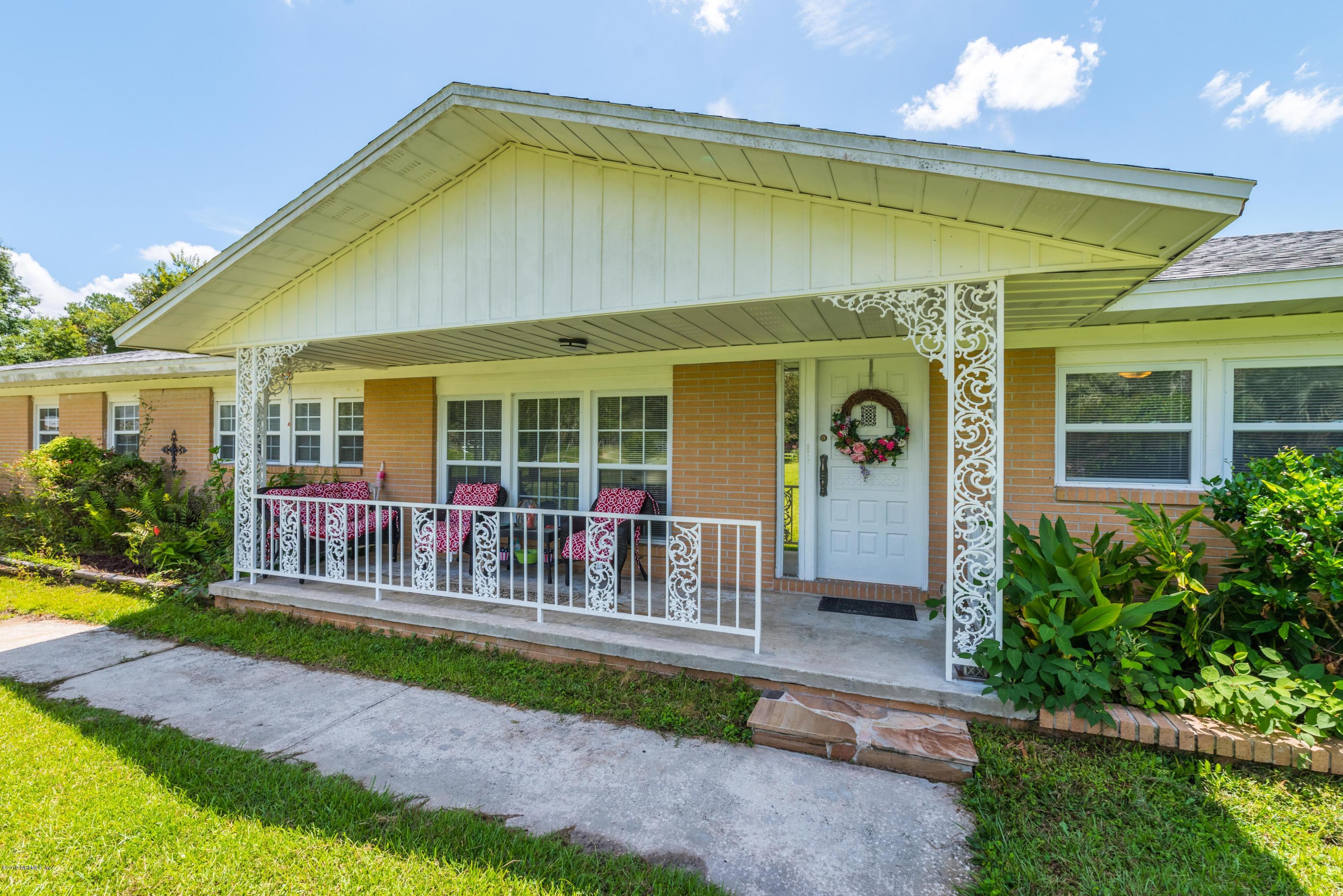54152 Snyder Road Callahan, FL 32011 - Photo 8 of 39 a porch with a table and chairs under an umbrella