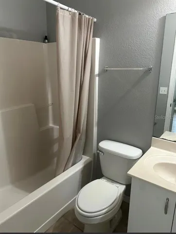 a white toilet sitting next to a bath tub