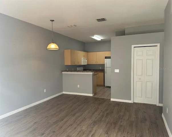 a view of a kitchen with wooden floor and a sink