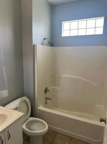 a bathroom with a granite countertop toilet a sink and bathtub