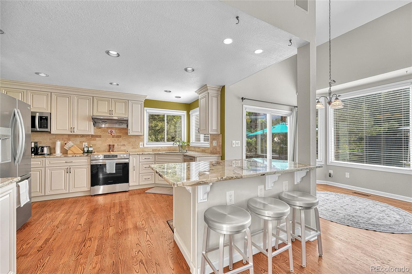 6722 Eagle Place Highlands Ranch, CO 80130 - Photo 11 of 47 a large kitchen with granite countertop a large counter top space a sink stainless steel appliances and cabinets