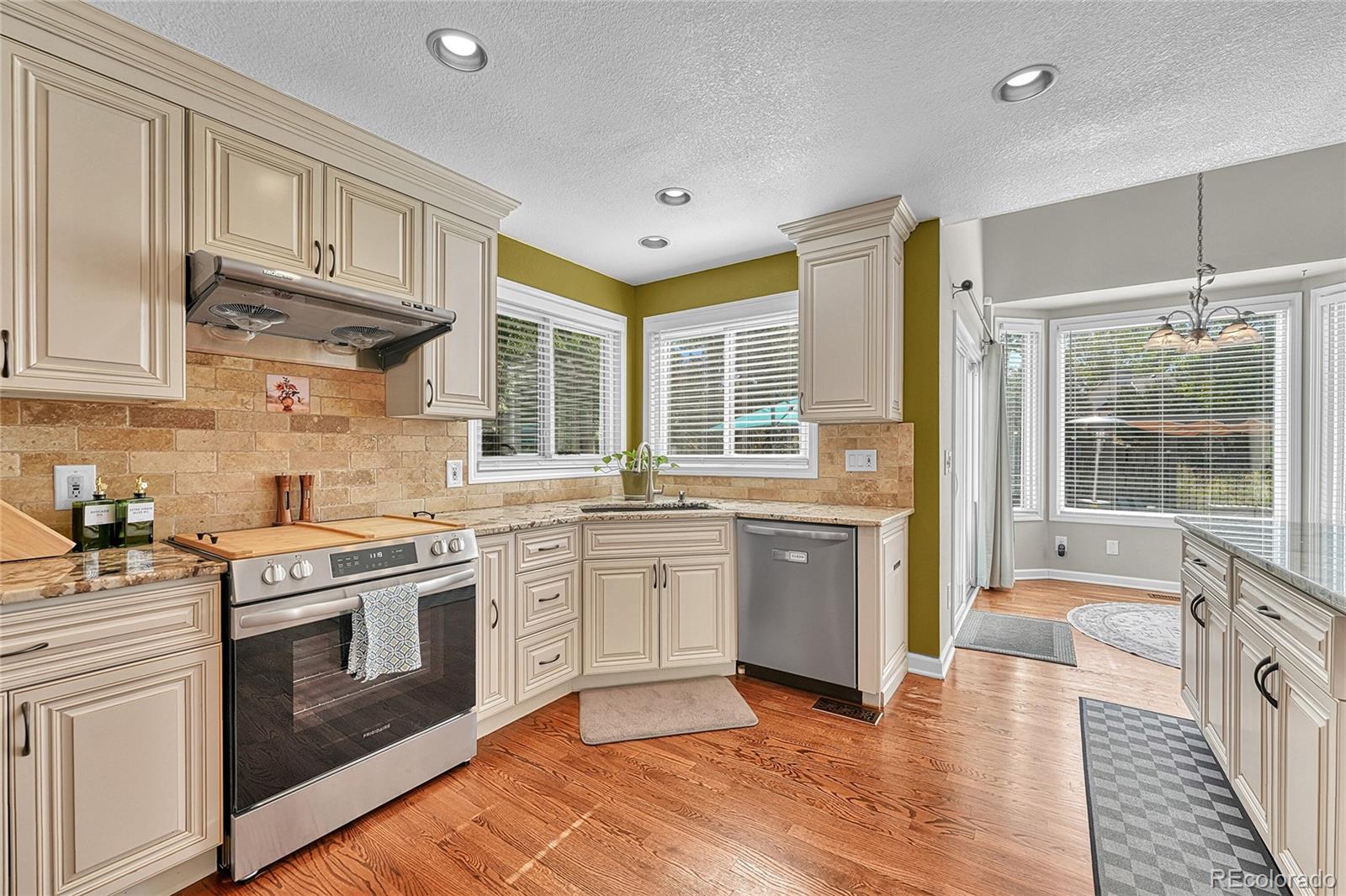 6722 Eagle Place Highlands Ranch, CO 80130 - Photo 12 of 47 a kitchen with stainless steel appliances granite countertop a stove and white cabinets