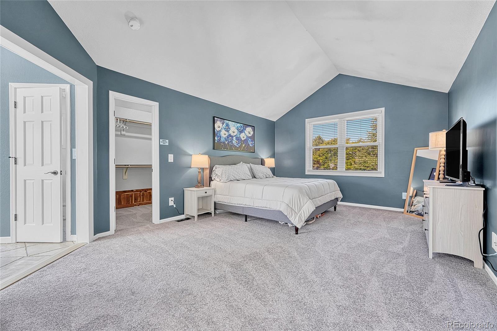 6722 Eagle Place Highlands Ranch, CO 80130 - Photo 20 of 47 a spacious bedroom with a bed and a flat tv screen on the dresser
