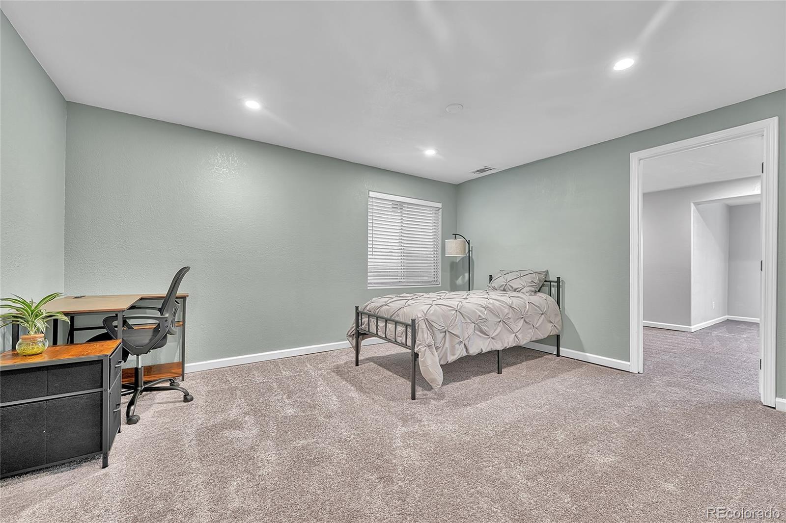6722 Eagle Place Highlands Ranch, CO 80130 - Photo 28 of 47 a spacious bedroom with a bed and a desk in it