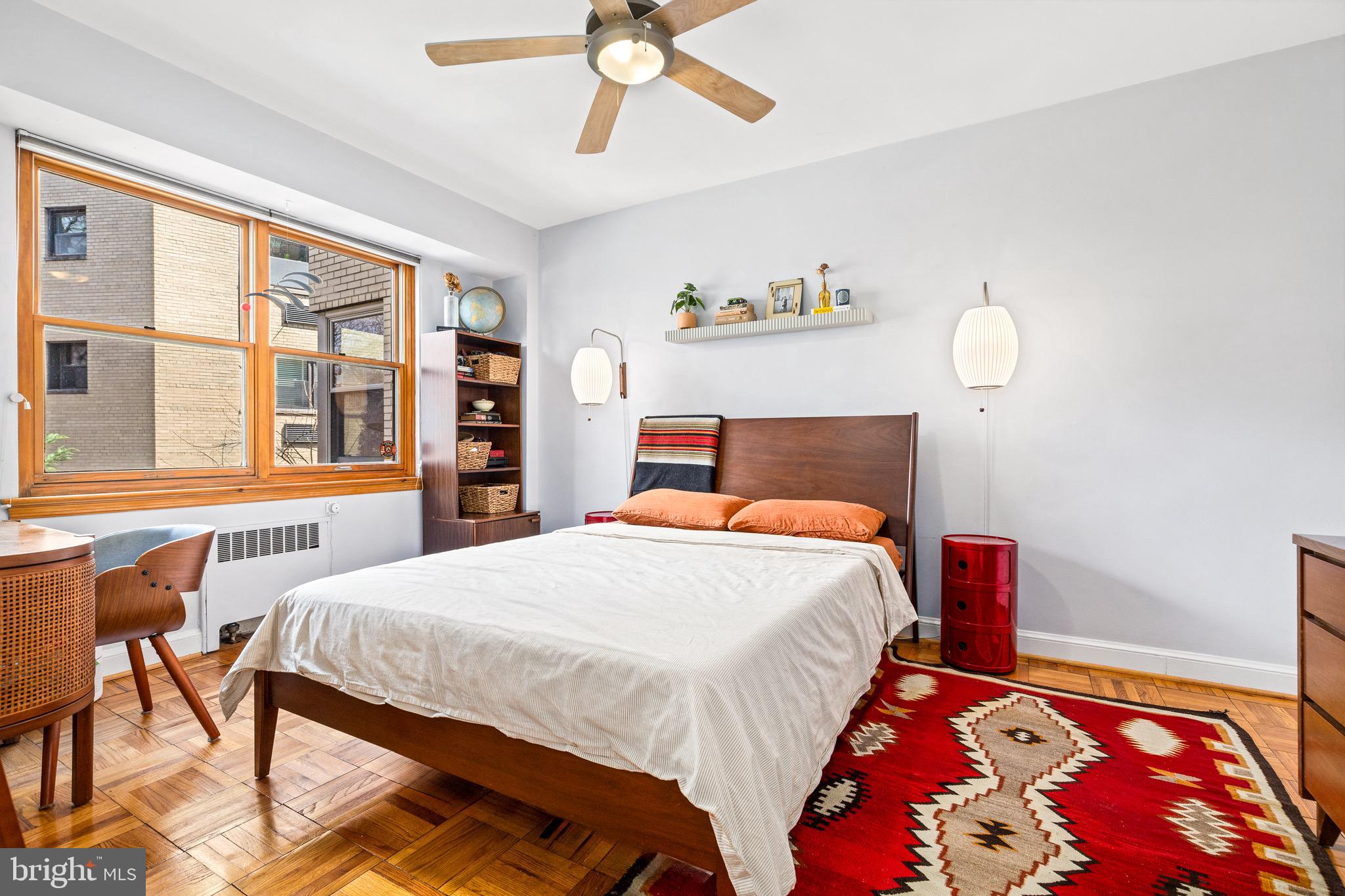 3025 Ontario Road Northwest, Unit 207 Washington, DC 20009 - Photo 12 of 15 a bedroom with a bed and a chandelier
