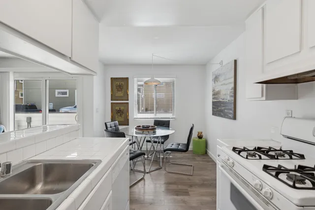 a living room with furniture a dining table and chairs with wooden floor