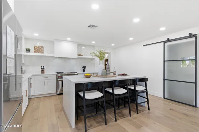 a kitchen with white cabinets and stainless steel appliances