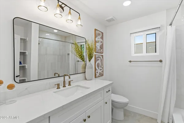a bathroom with a double vanity sink toilet and mirror