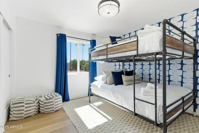 a bedroom with a bed a couch and a painting on the wall