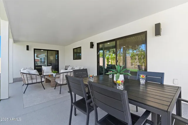 a vase of flowers sitting on a table with a potted plant