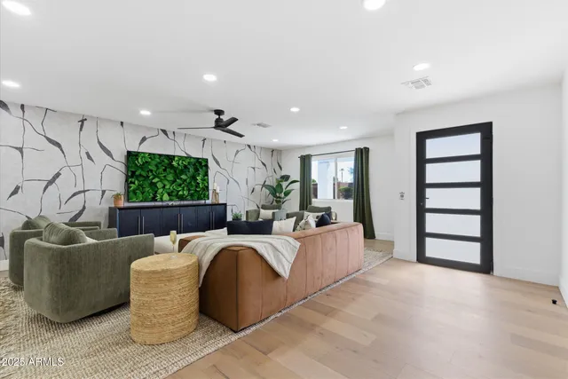 a living room with furniture a large window and a flat screen tv