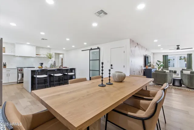 a kitchen with kitchen island a dining table and chairs
