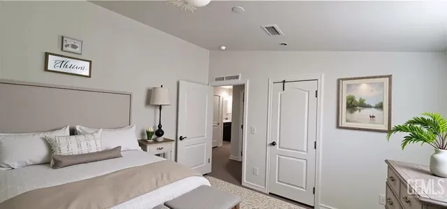 a bedroom with a bed and a potted plant