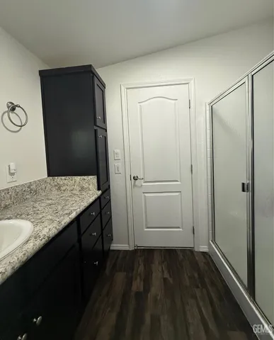 a bathroom with a granite countertop sink and a mirror