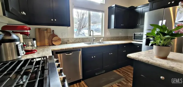 a kitchen with stainless steel appliances granite countertop a sink stove and cabinets