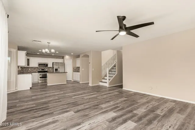 a kitchen with stainless steel appliances kitchen island granite countertop a refrigerator and a sink