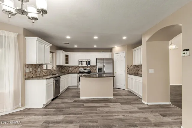 a view of a hallway with wooden floor and entryway