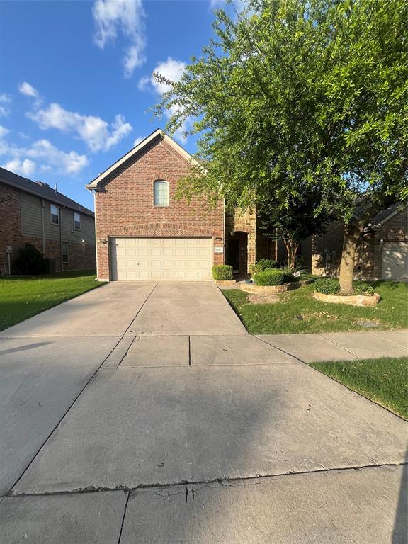 a front view of a house with a yard and trees