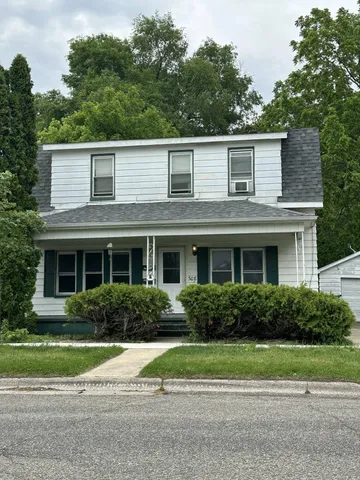 a house that has a lot of plants in front of it