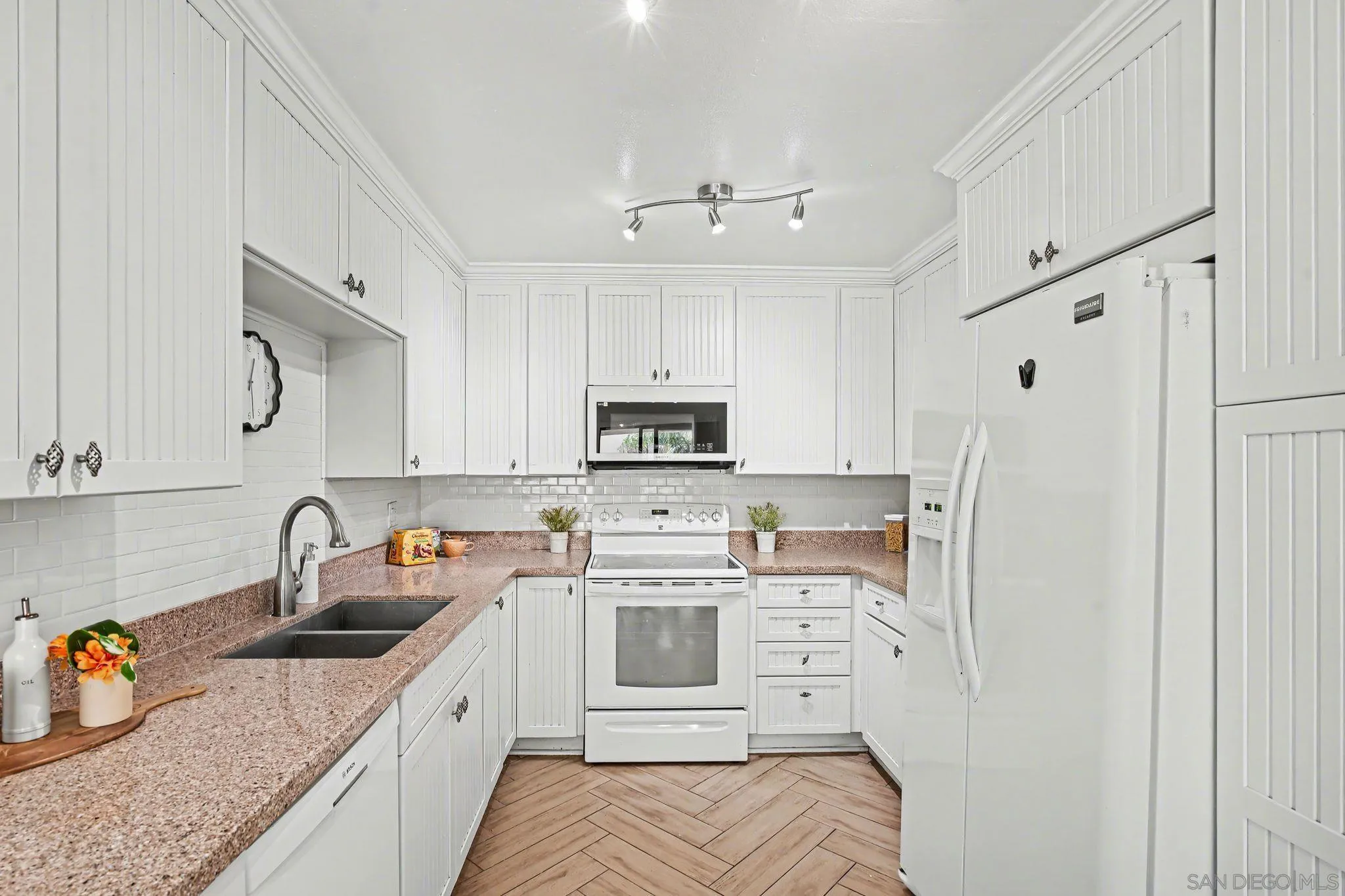 6757 Friars Road, Unit 21 San Diego, CA 92108 - Photo 8 of 40 a kitchen with stainless steel appliances granite countertop a sink dishwasher a refrigerator and white cabinets with wooden floor