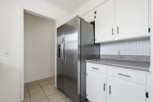 a kitchen with stainless steel appliances granite countertop a stove a refrigerator and a white cabinets