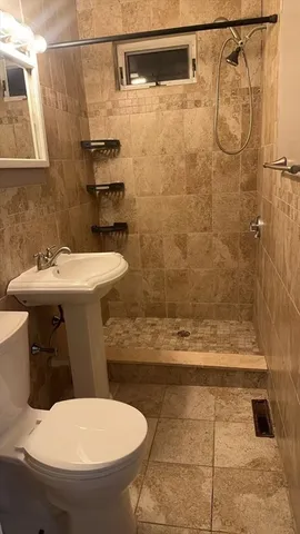 a bathroom with a sink a toilet and shower