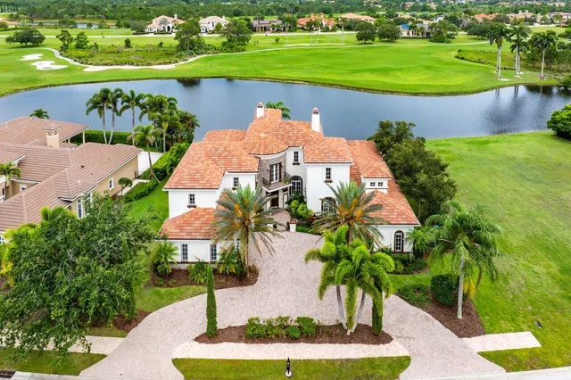 an aerial view of a house with a garden and lake view