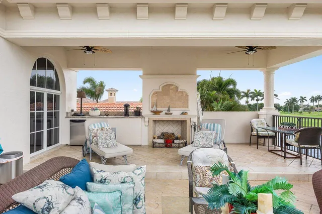 a view of a patio with couches chairs potted plants and lake view