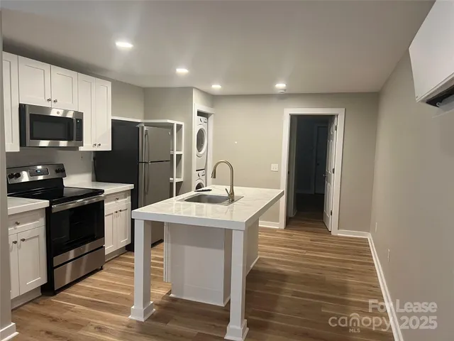 a kitchen with a sink a refrigerator and a stove top oven