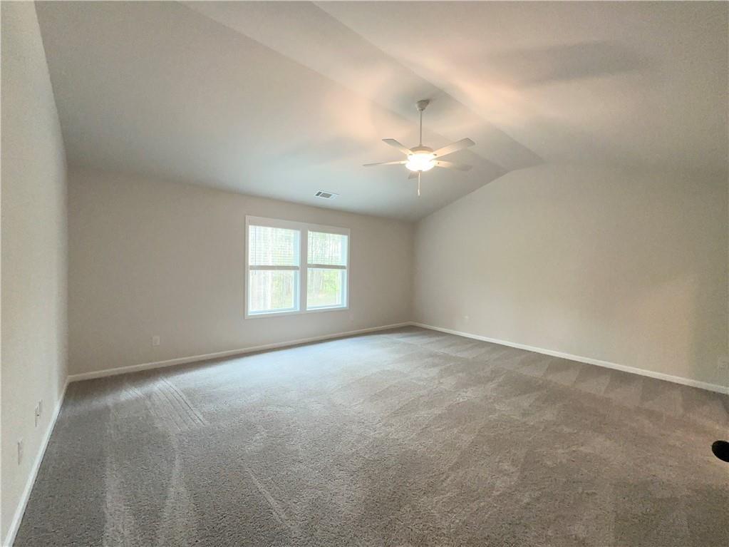 345 Rodeo Drive Auburn, GA 30011 - Photo 15 of 22 an empty room with a chandelier fan and windows