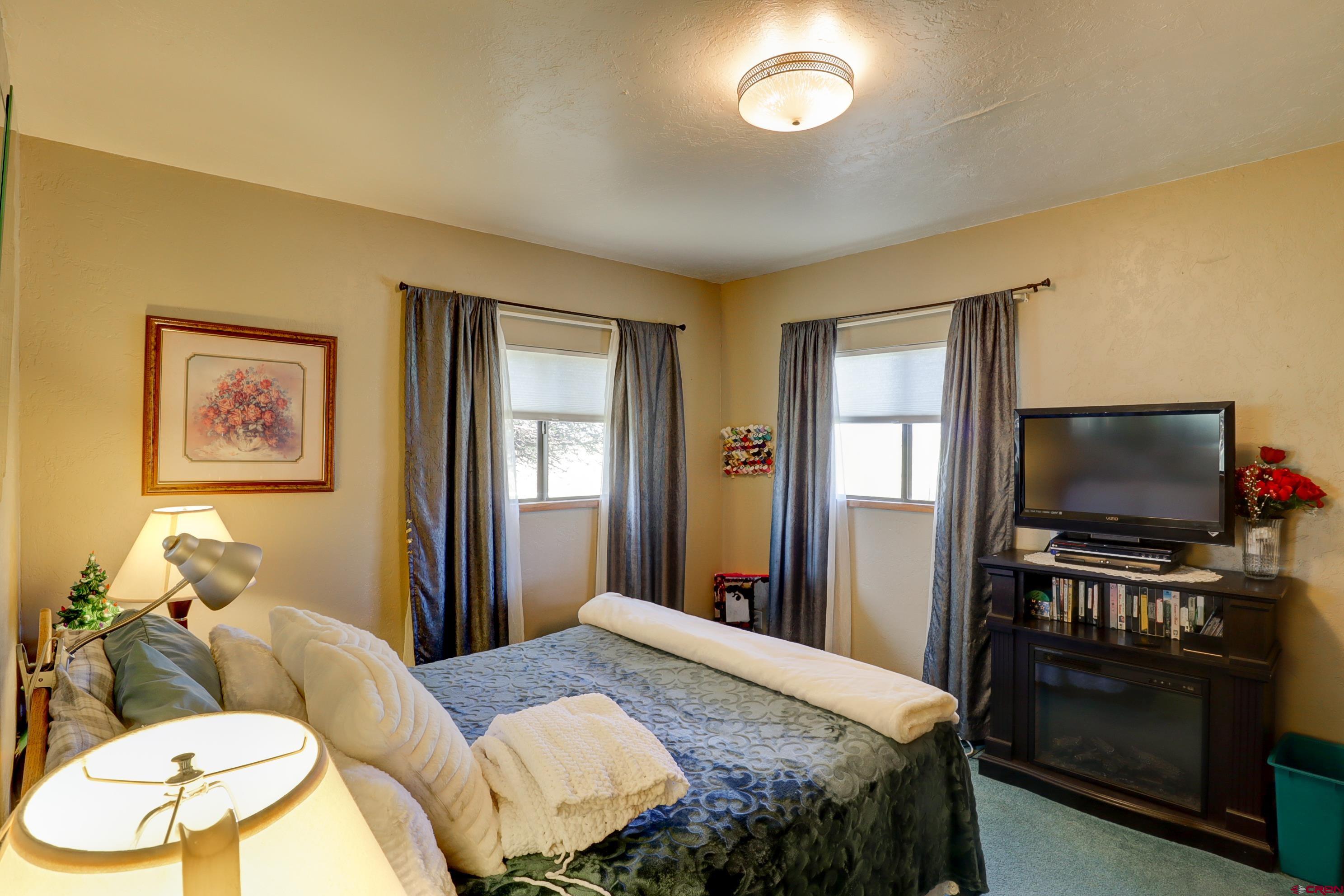 22705 Rd L Cortez, CO 81321 - Photo 21 of 30 a bedroom with a bed and a flat screen tv