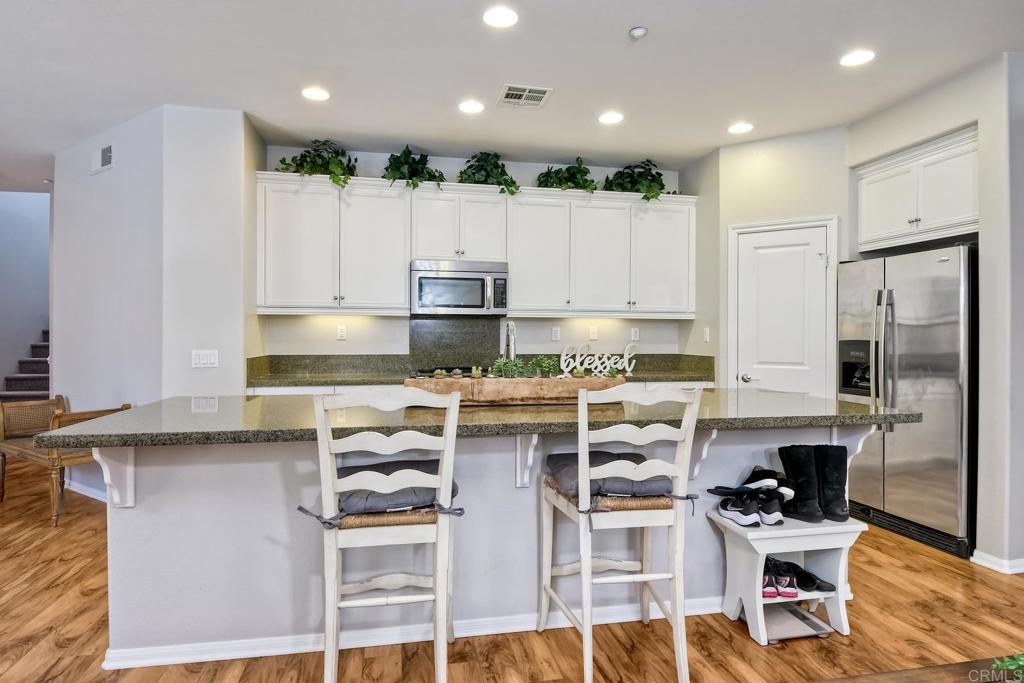 2256 Flatiron Way San Marcos, CA 92078 - Photo 5 of 22 a kitchen with kitchen island granite countertop appliances cabinets and a sink