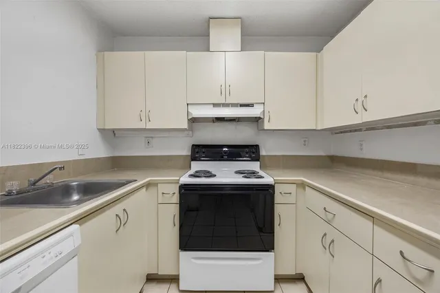 a kitchen with granite countertop white cabinets and white stainless steel appliances