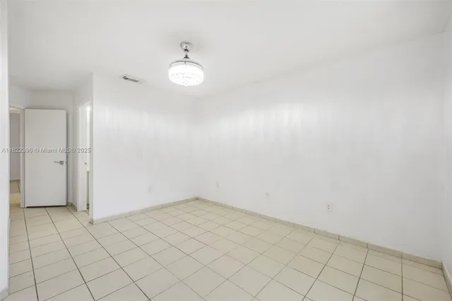 an empty room with white walls and tiles