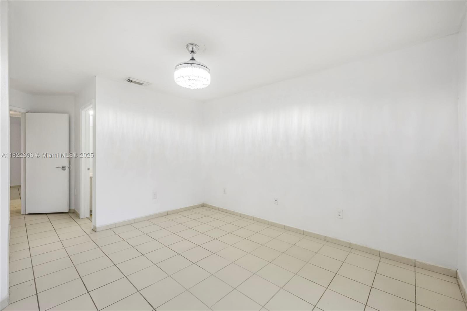 8421 Southwest 209th Street, Unit 8421 Cutler Bay, FL 33189 - Photo 7 of 16 an empty room with white walls and tiles