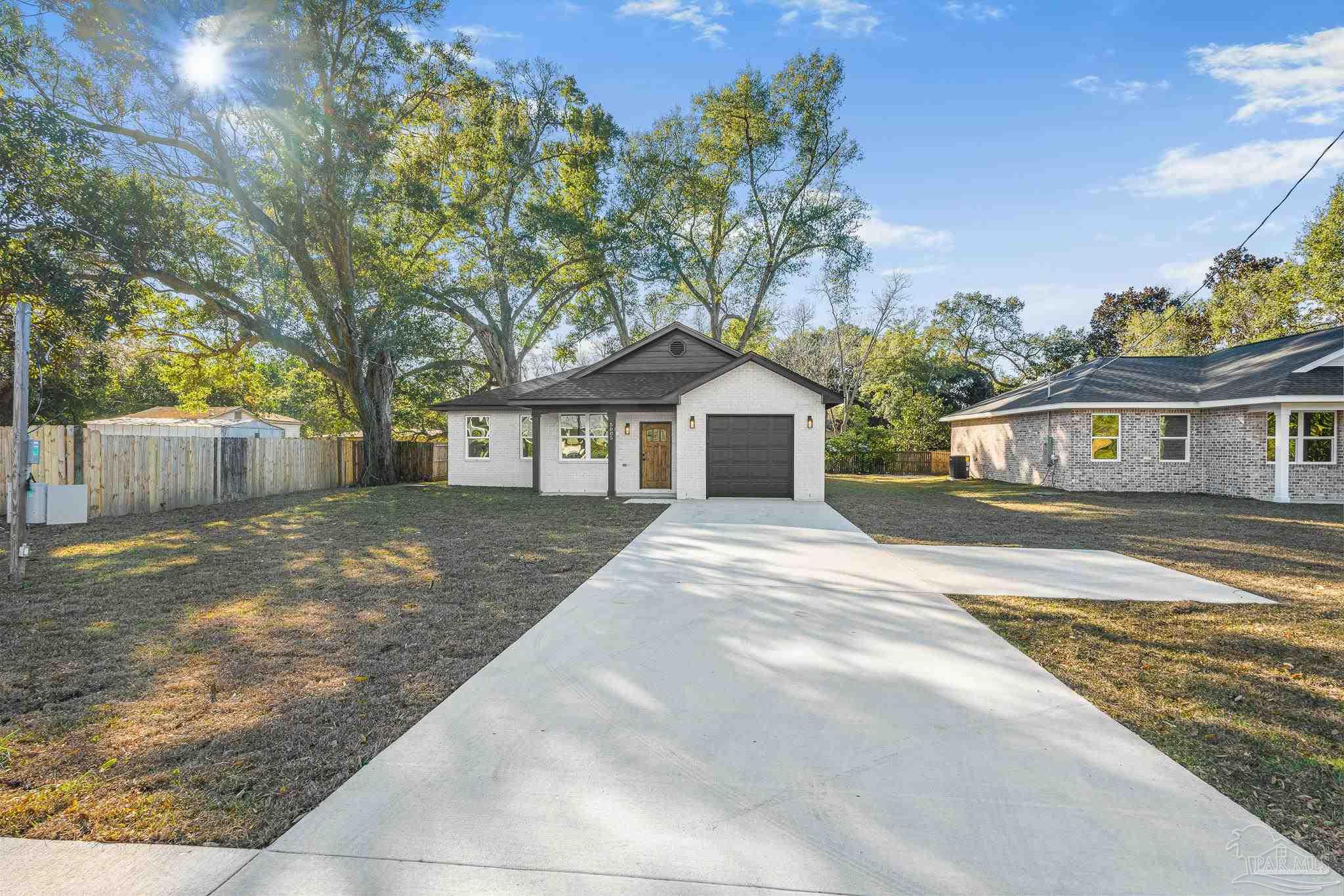 5005 Saufley Field Road Pensacola, FL 32526 - Photo 24 of 27 a front view of a house with a yard and garage