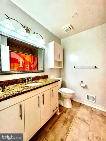 a bathroom with a sink a toilet and a mirror