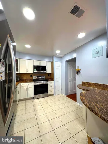 a large kitchen with a stove a sink and a refrigerator