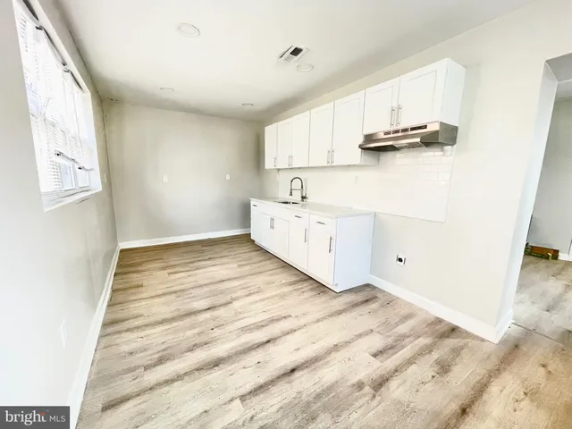 a view of kitchen and hall with wooden floor