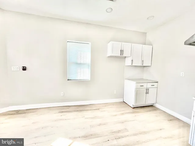 a view of a kitchen with an empty space and a window