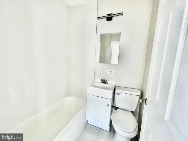 a white toilet sitting next to a bathroom sink and tub