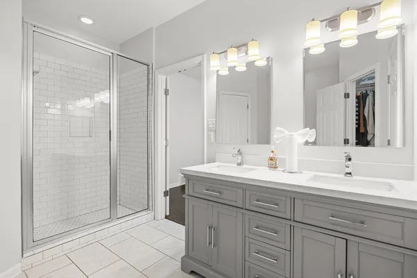 a bathroom with a double vanity sink mirror and shower