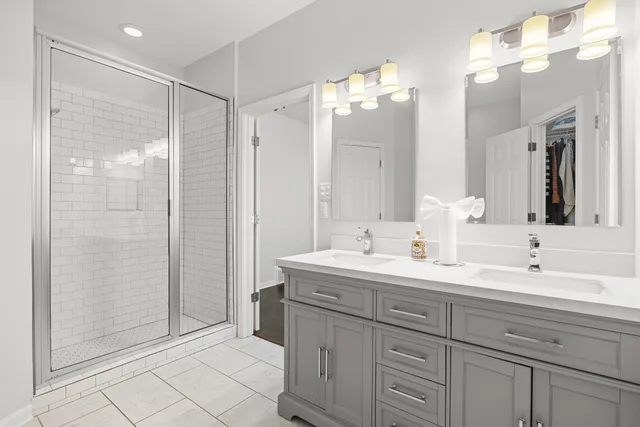 a bathroom with a double vanity sink mirror and shower