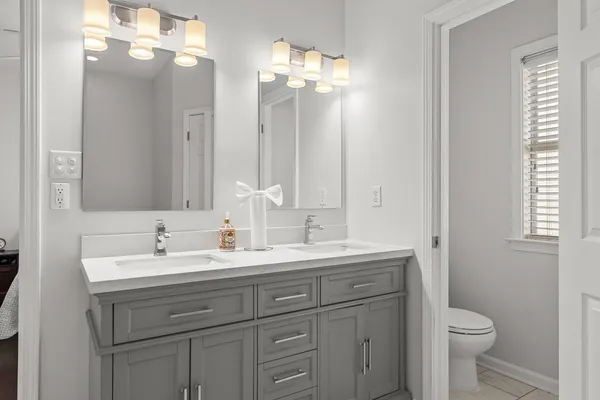 a bathroom with a double vanity sink and a mirror