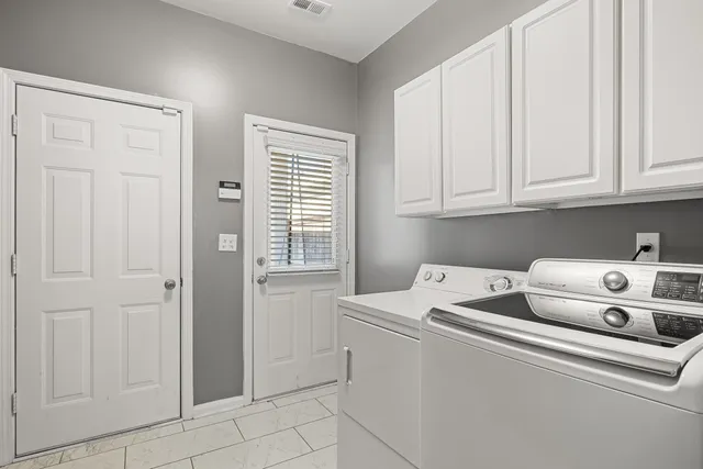 a utility room with dryer washer and a window