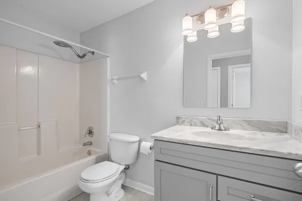 a bathroom with a granite countertop sink a toilet and shower