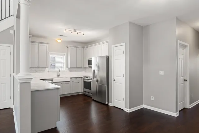 a kitchen with a refrigerator sink and cabinets