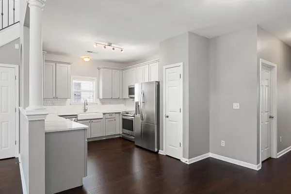 a kitchen with a refrigerator sink and cabinets